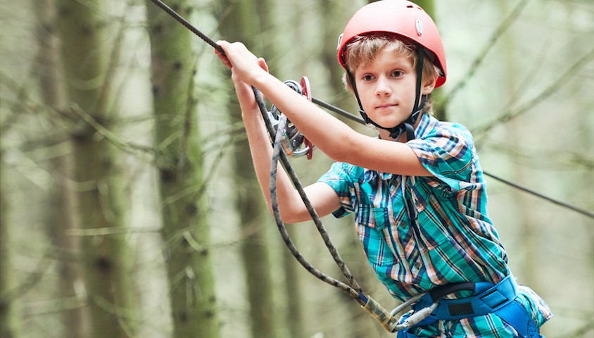 Boy on high ropes course.